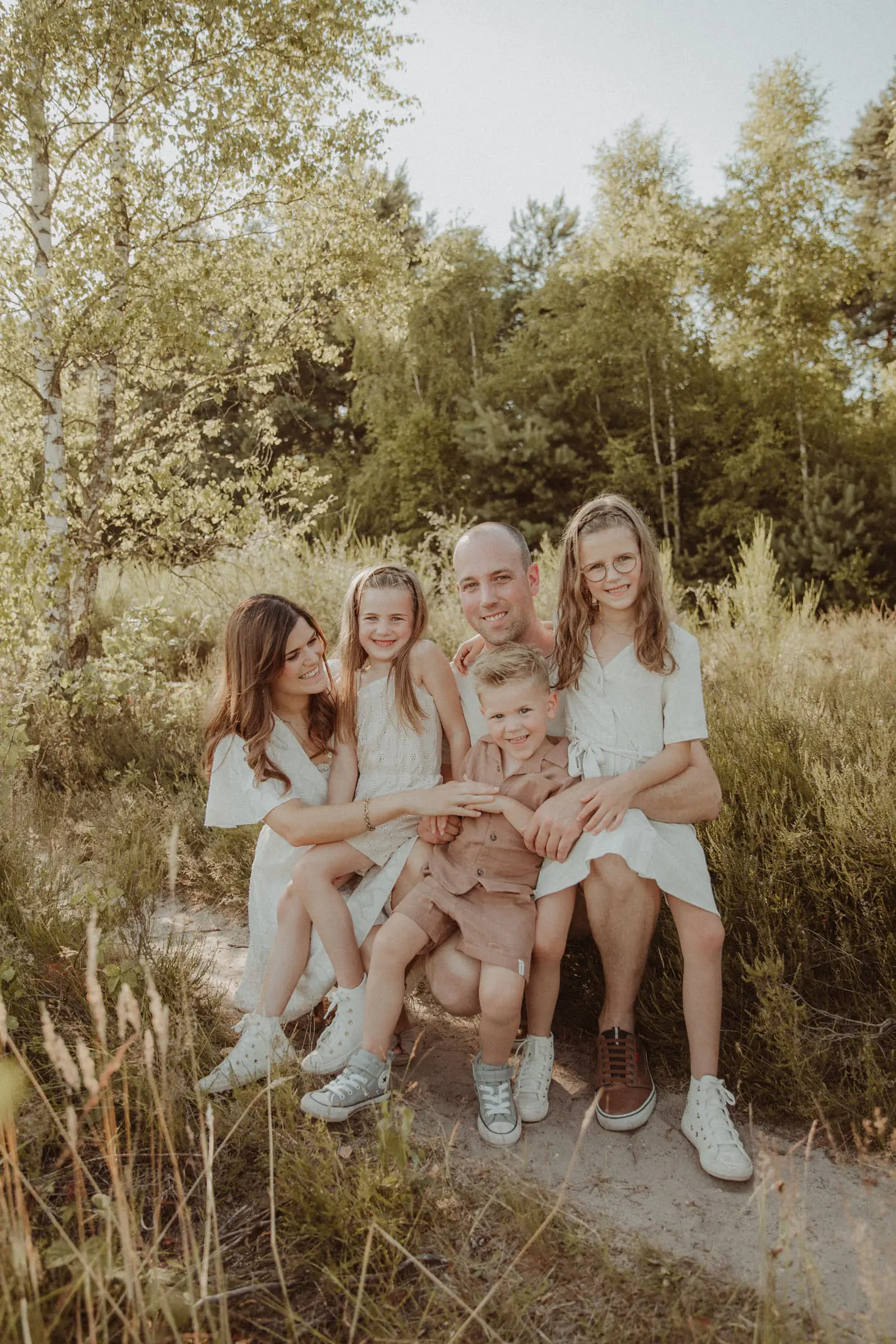 Moeder zit samen met haar kinderen in het gras