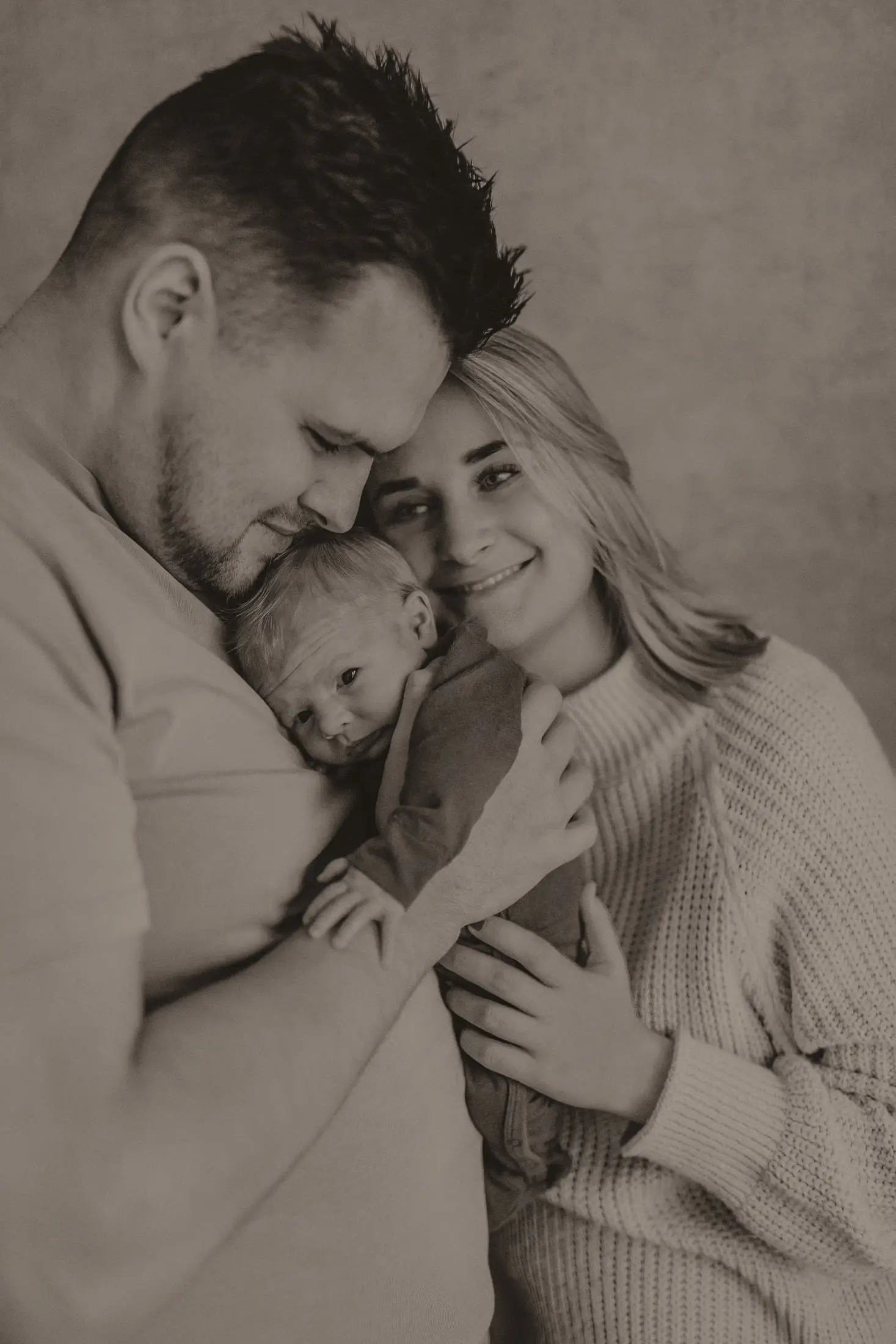 Ouders houden hun baby samen dicht tegen zich aan