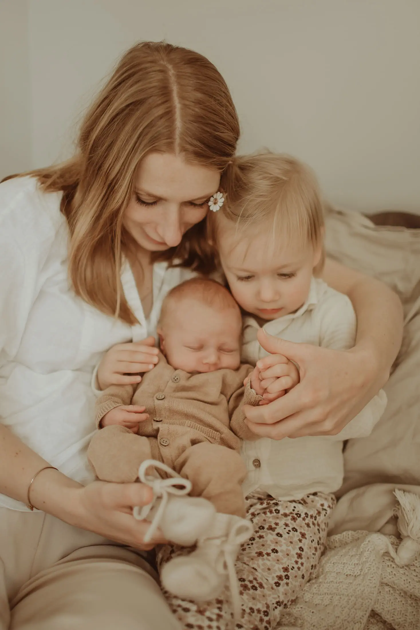 Moeder zit met haar kinderen en pasgeboren baby